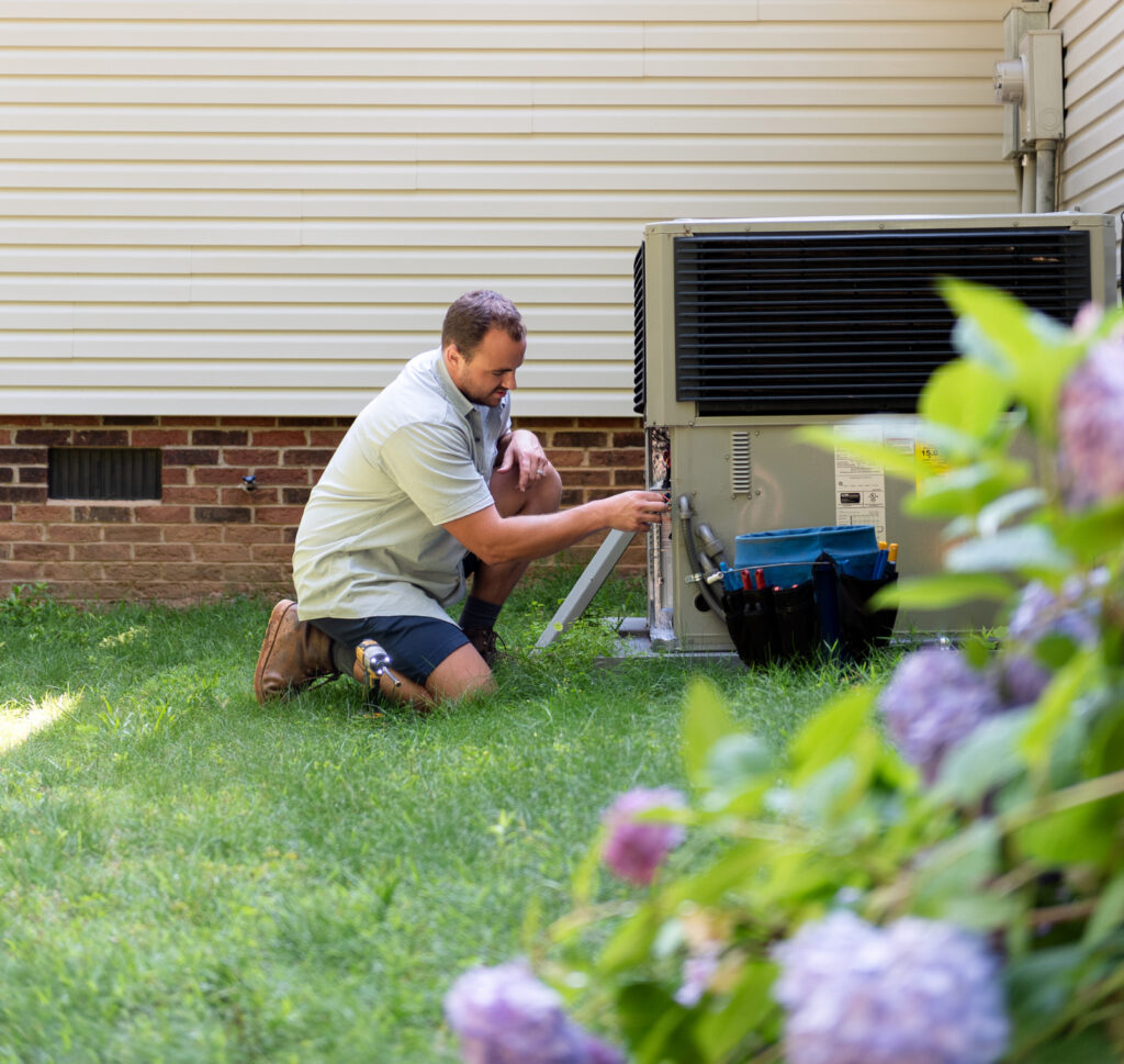 a Travis Crawford HVAC technician performs AC repair at a home in Charlotte, NC