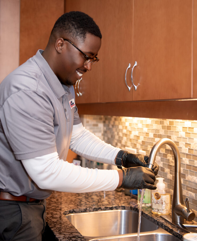 a Travis Crawford plumber installs a new kitchen sink in a Charlotte, NC home