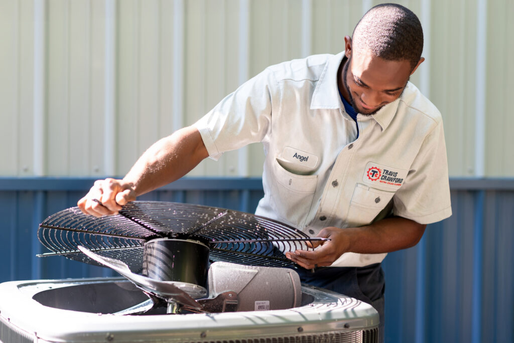 a Travis Crawford HVAC technician performs maintenance on an air conditioner in Charlotte, NC