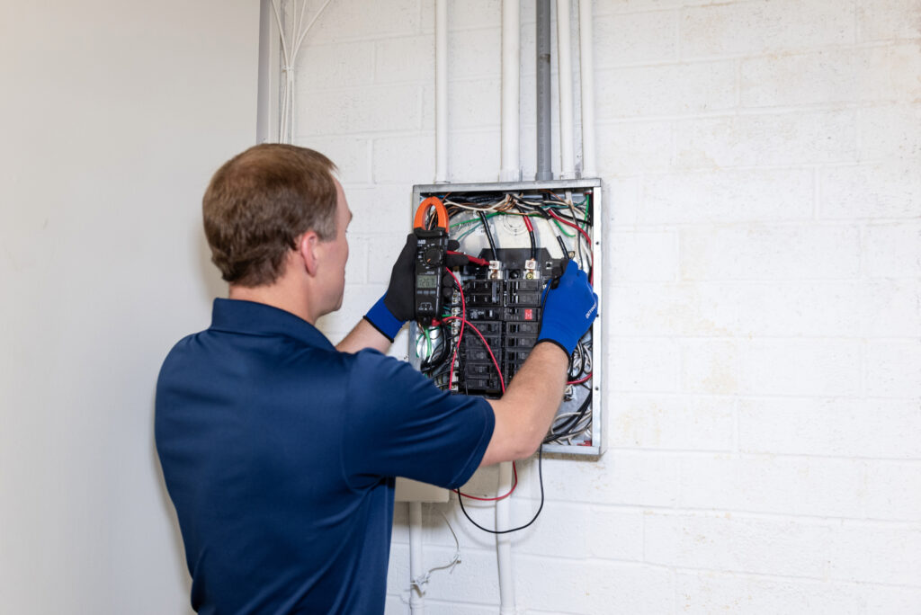 a Travis Crawford electrician inspects a panel as part of wiring services in Charlotte, NC