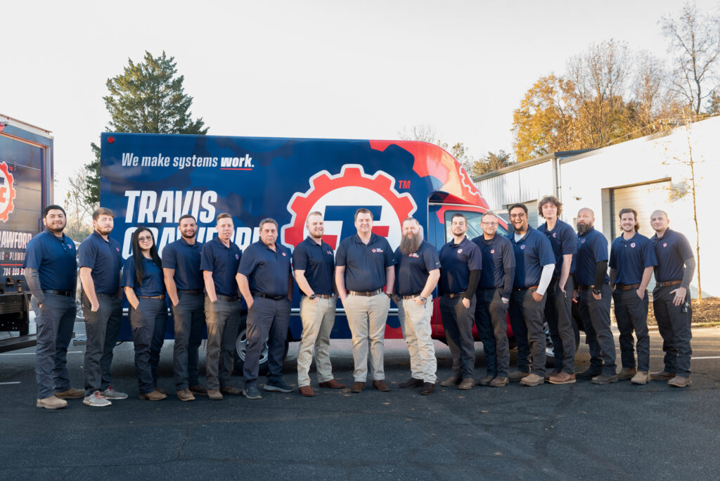 the Travis Crawford HVAC team poses in front of a branded vehicle in Charlotte, NC, ready to perform HVAC, plumbing, and electrical service