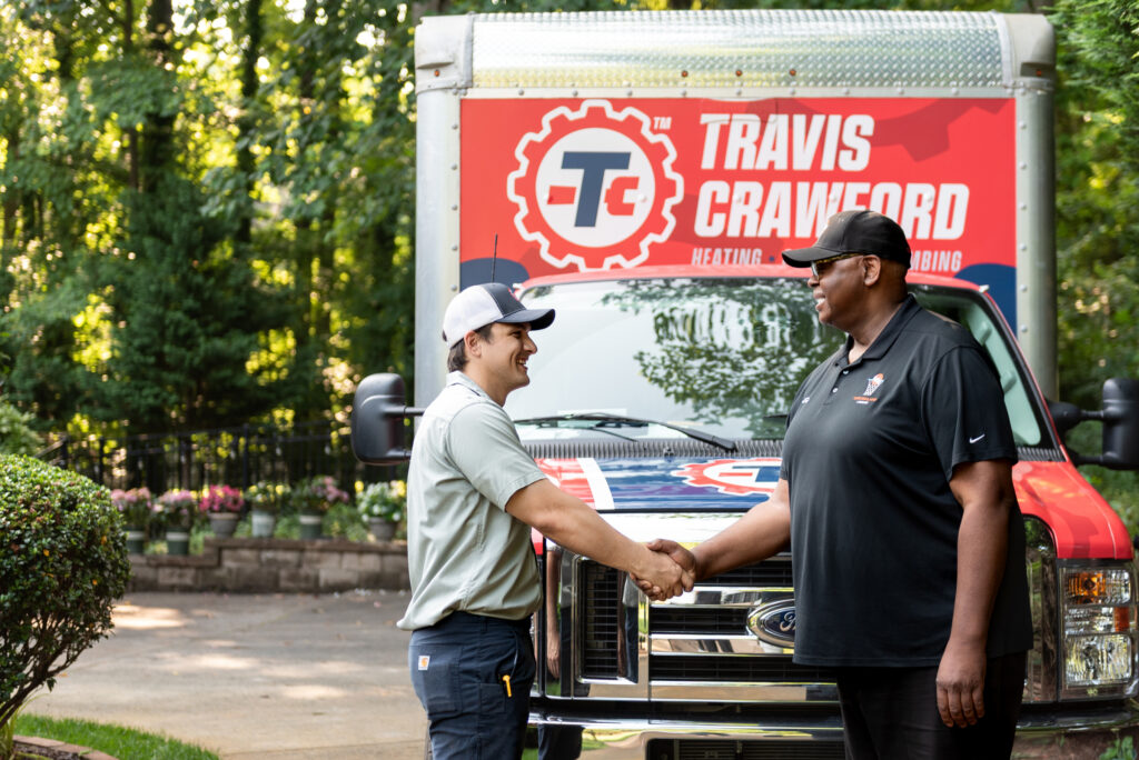 a Travis Crawford technician shakes the hand of a customer about to get a heating system replacement in Charlotte