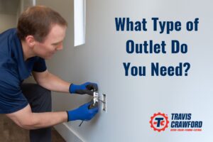 an electrician from Travis Crawford installs a new outlet in an office in Charlotte, NC